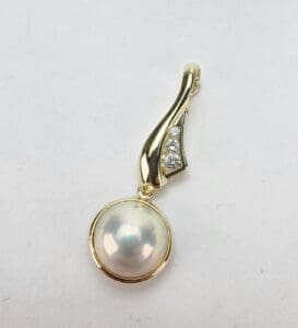Gold pendant with pearl and diamonds.