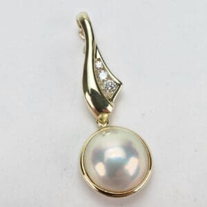 Gold pendant with pearl and diamonds.