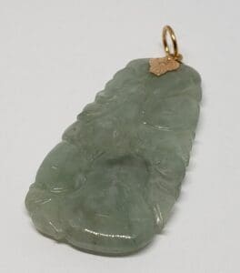 Green jade pendant with gold loop.