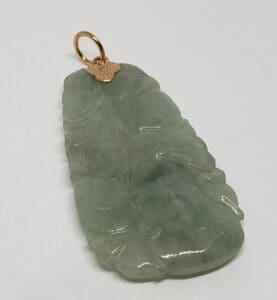 Green jade pendant with gold loop.