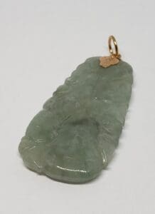 Green jade pendant with gold loop.