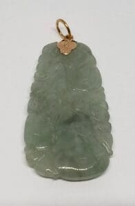 Green jade pendant with gold loop attachment.