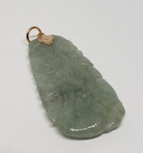 Green jade pendant with gold ring.