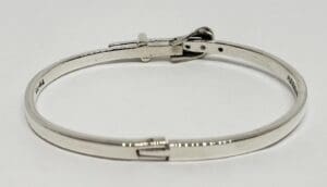 Silver bracelet with clasp on white background.