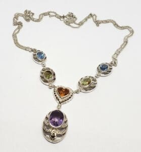 Silver necklace with colorful gemstone pendants.
