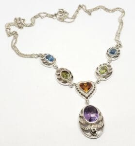 Silver necklace with colorful gemstone pendants.