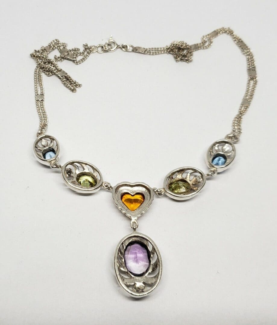 Silver necklace with colorful gemstone pendants.