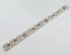 Silver bracelet with red gemstone accents.