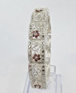 Silver bracelet with intricate floral designs.