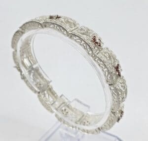 Intricate silver bracelet with red accents.