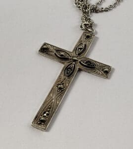 Ornate silver cross pendant with chain.