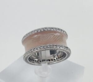 Silver band with pink enamel and diamonds.