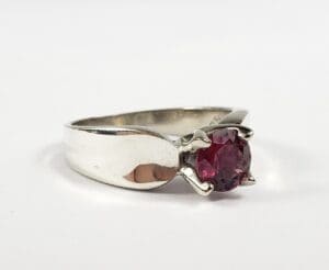 Silver ring with a red gemstone.