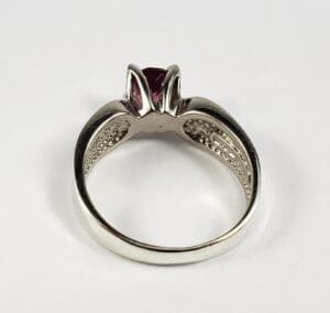 Silver ring with red gemstone and details.