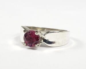 Silver ring with a red gemstone.
