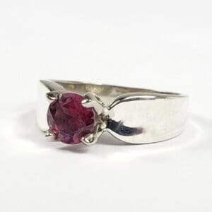 Silver ring with a red gemstone.