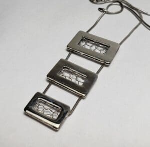 Geometric silver necklace with rectangular pendants.