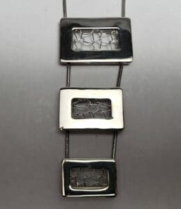 Geometric silver necklace with rectangular pendants.