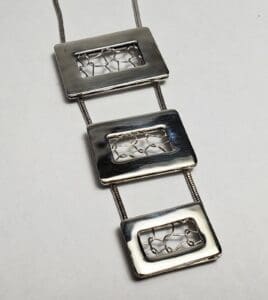 Silver rectangular pendant necklace with wire design.
