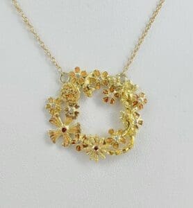 Gold floral pendant on a delicate chain.