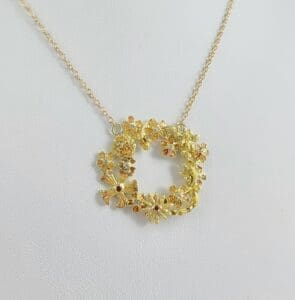 Gold floral pendant necklace on display.