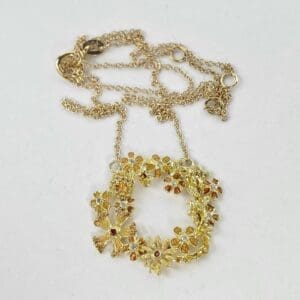 Gold floral wreath necklace on chain.