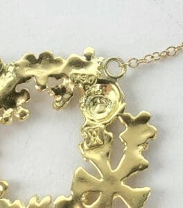 Gold chain with detailed pendant design.