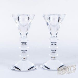 Two clear glass candlestick holders on display.