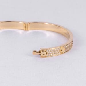 Gold bracelet with diamond accents, open clasp.