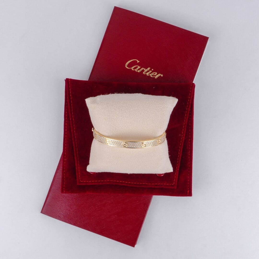 Gold bracelet on red Cartier pouch.