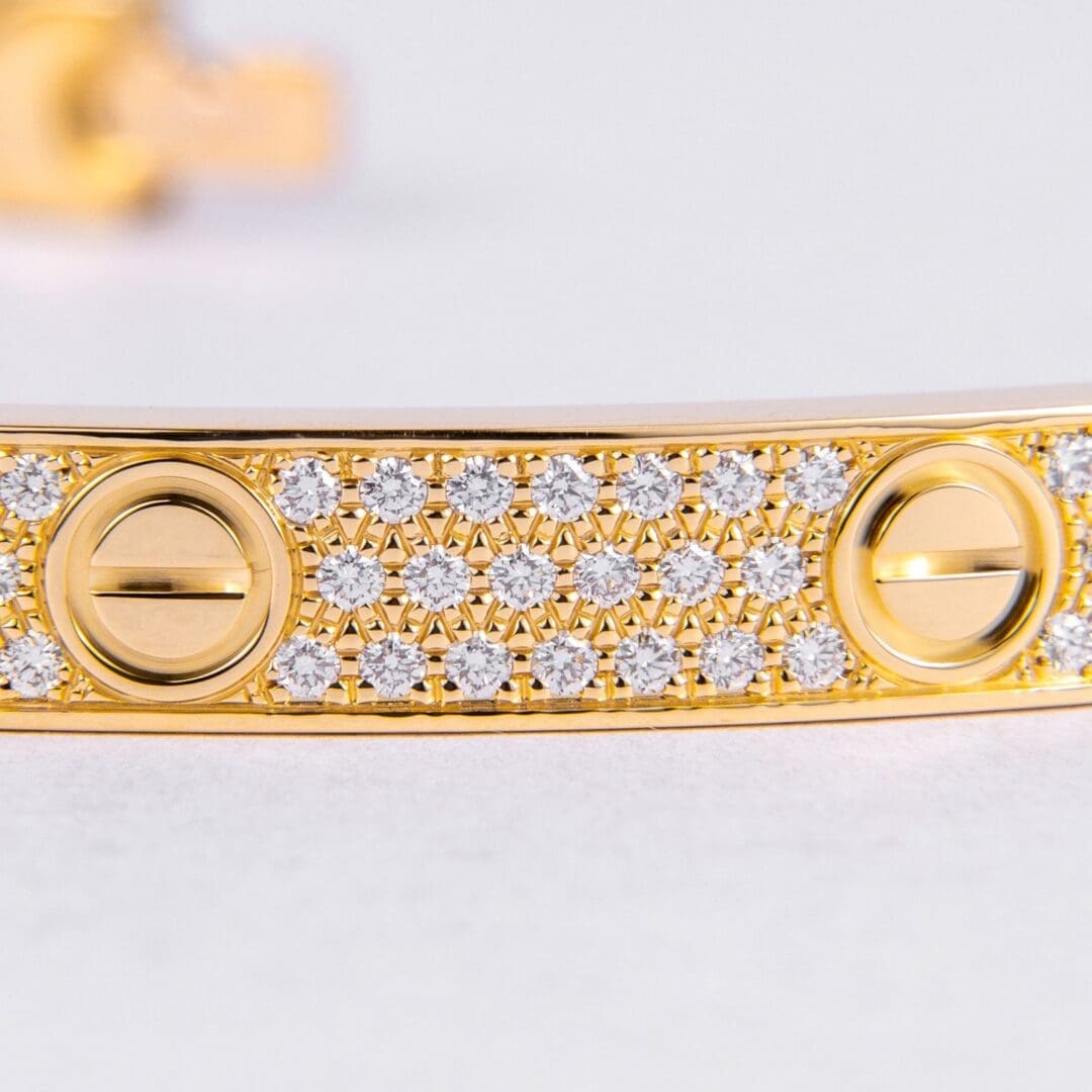Gold bracelet with diamonds and circular details.