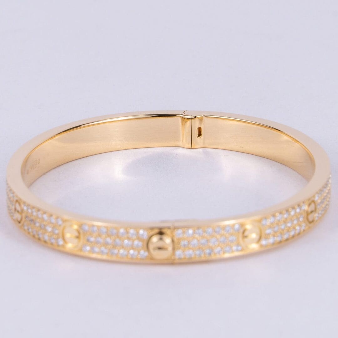 Gold bracelet with diamond accents and screws.