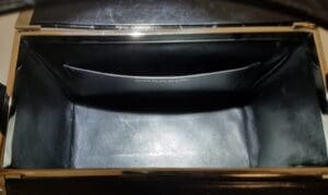 Open empty black leather handbag interior.