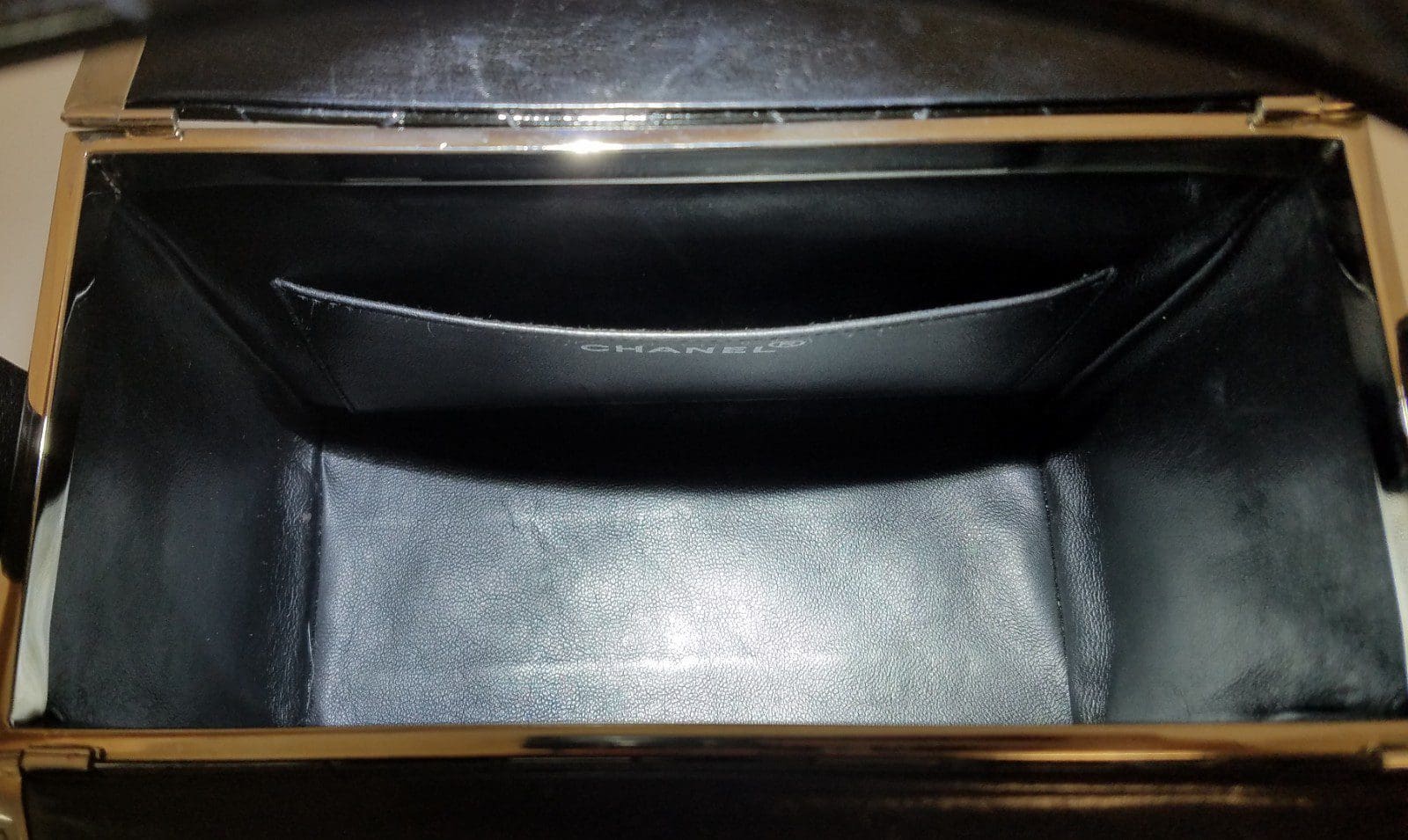 Open empty black leather handbag interior.