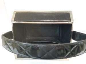 Open black leather handbag with metal frame.