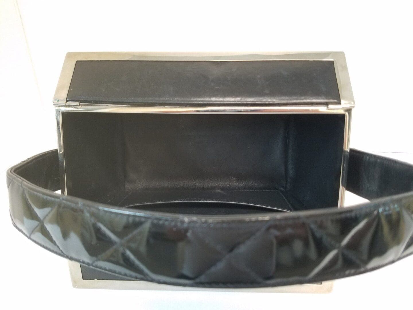 Open black leather handbag with metal frame.