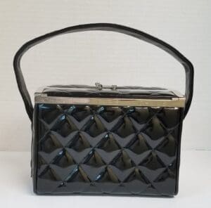 Black quilted handbag with top handle.