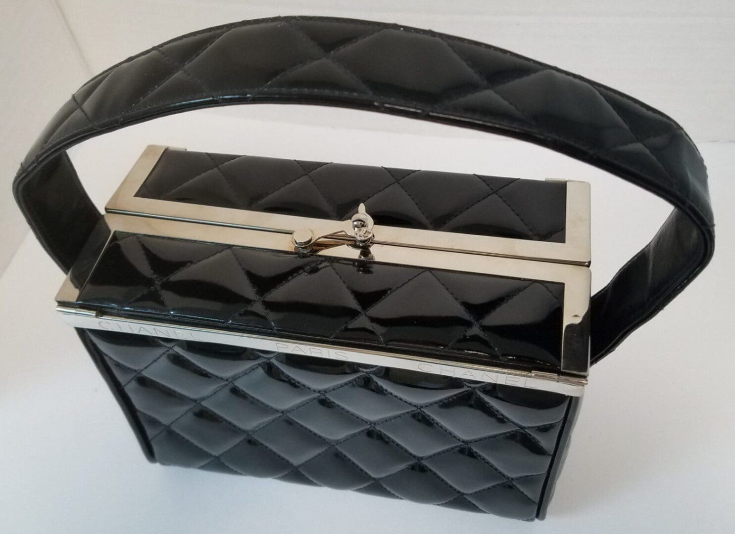 Quilted black handbag with a metal clasp.