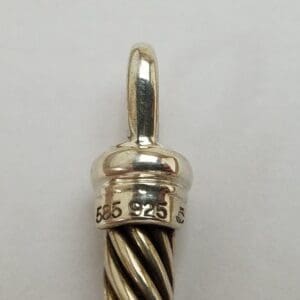 Silver and gold pendant with twisted design.