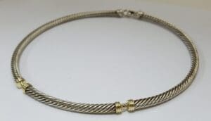 Silver twisted necklace with gold accents.