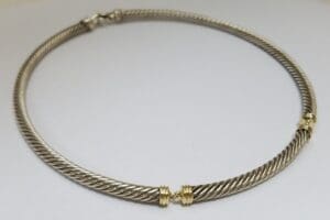 Silver twisted cable necklace with gold accents.