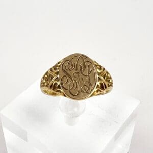 Gold signet ring with engraved initials.
