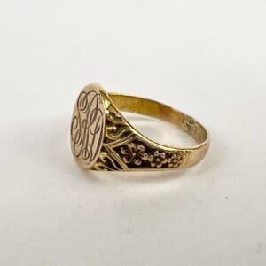 Gold ring with engraved initials and flowers.