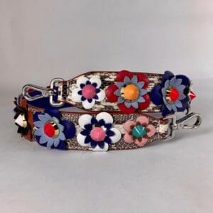 Colorful floral handbag straps with metal clasps.