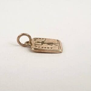 Gold pendant with engraved design.