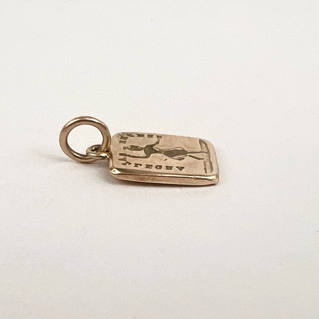 Gold pendant with engraved design.