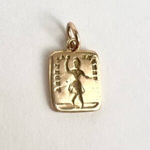 Gold pendant with engraved figure and text.