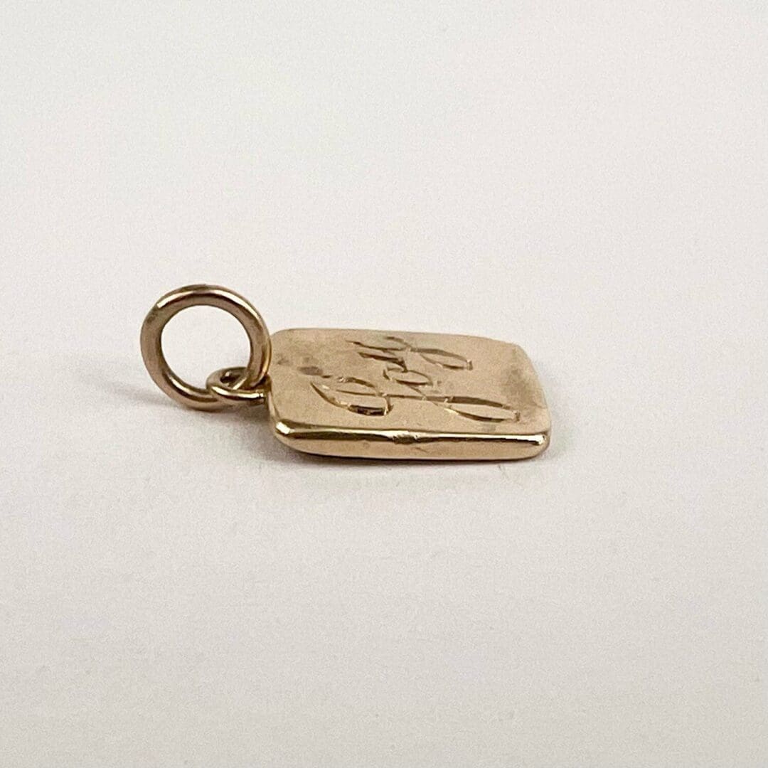 Gold pendant with engraved design.