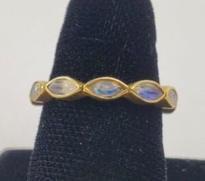 Gold ring with oval gemstones displayed.