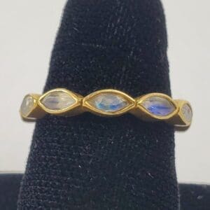 Gold ring with oval gemstones displayed.